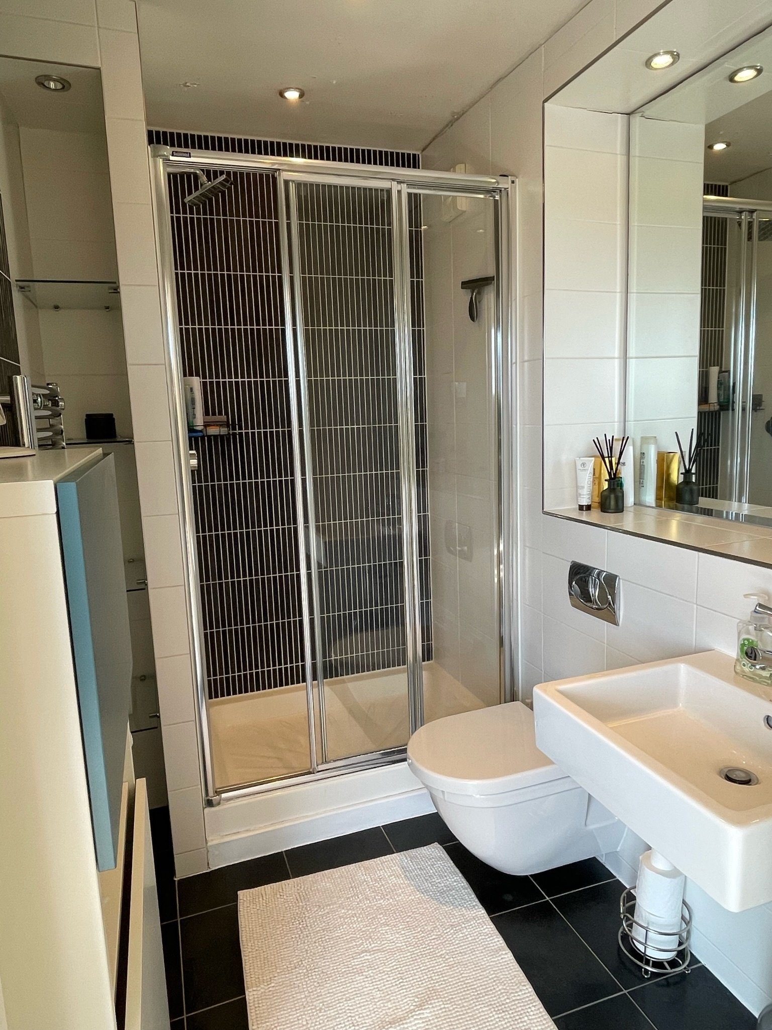 Family bathroom with shower enclosure, basin and large mirror