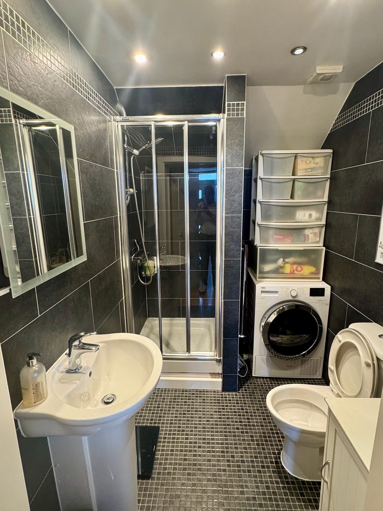 En-suite bathroom with dark slate tiling and mosaic floor