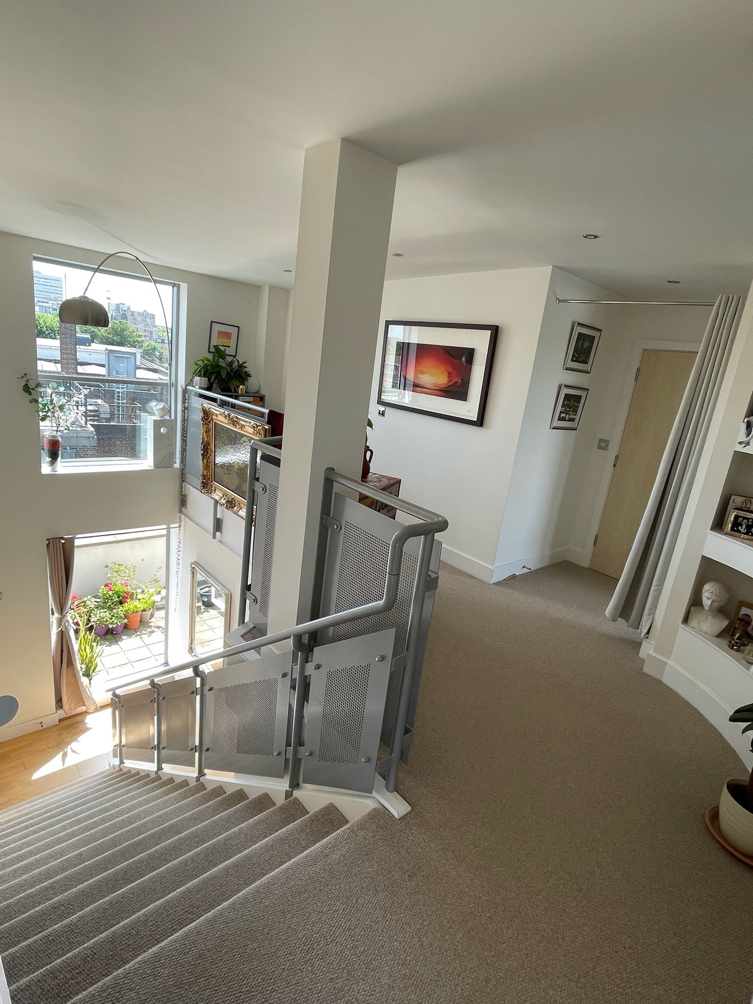 The duplex's double-height central stair, looking down from the upper floor